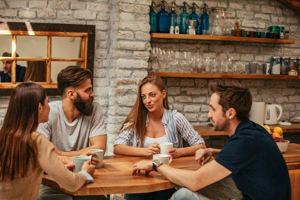 Group enjoying TRIBE COUNSEL Medium Blend coffee, City roast, in a cozy setting.